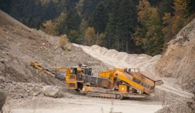 Industrial crusher machine in quarry: Illustrating the stark reality of environmental degradation caused by resource extraction and heavy machinery.